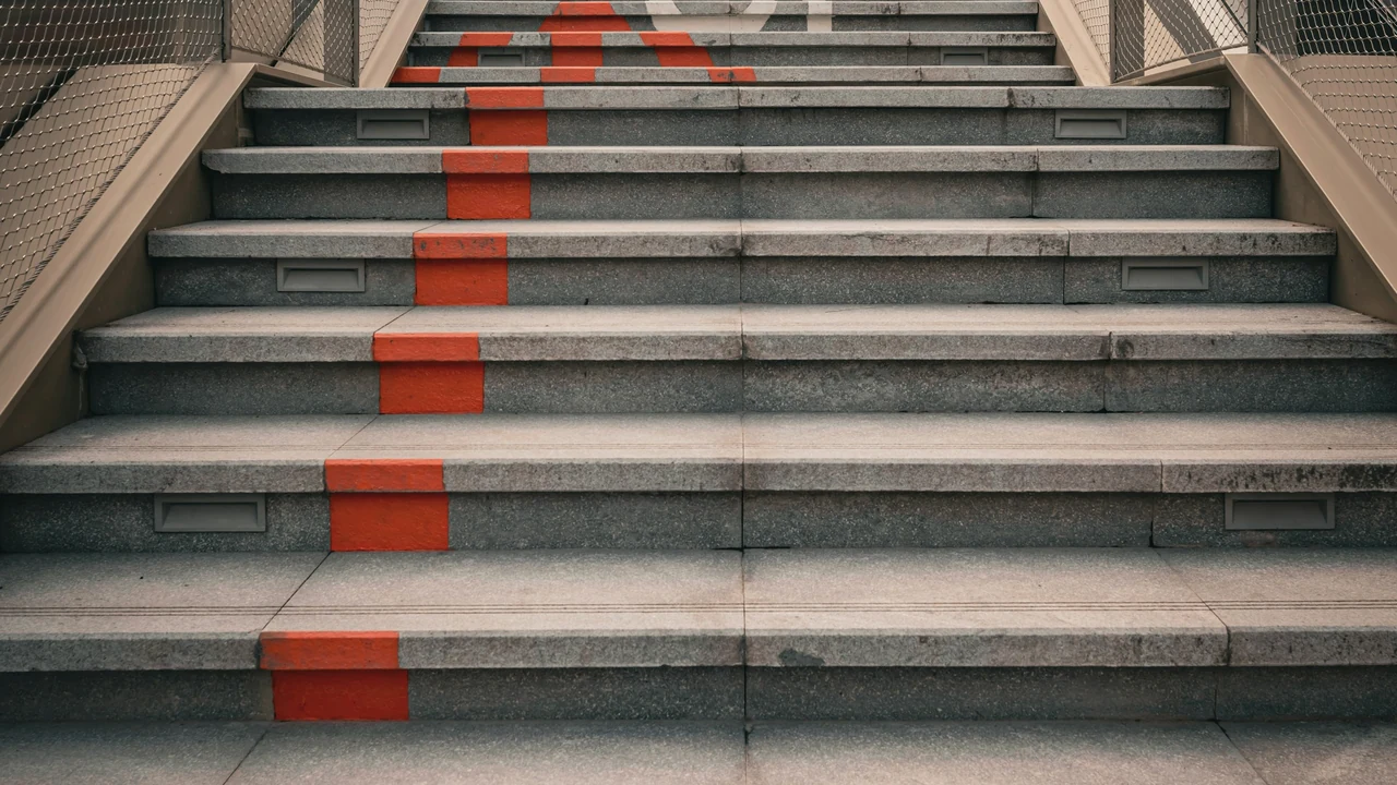 Sunlit architectural stairs rising through a modern building.