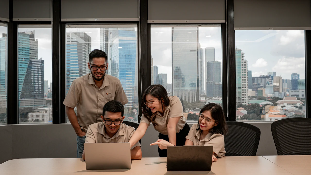 Team collaborating on laptops in a modern office.