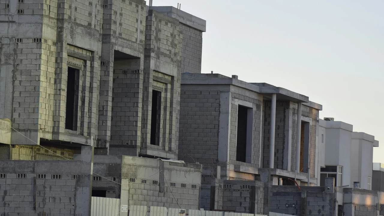 Authentic photograph of row of houses under construction against sky.