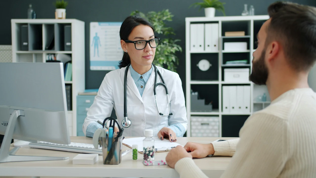 Authentic photograph of doctor consults with patient in medical office.