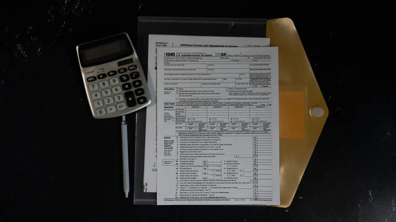 Authentic photograph of calculator and papers in a folder on a dark surface.