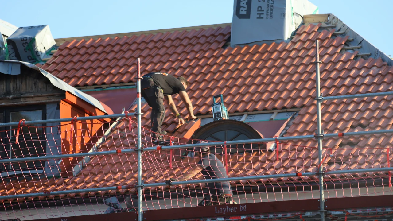 Authentic photograph of a man on a roof working on a roof.