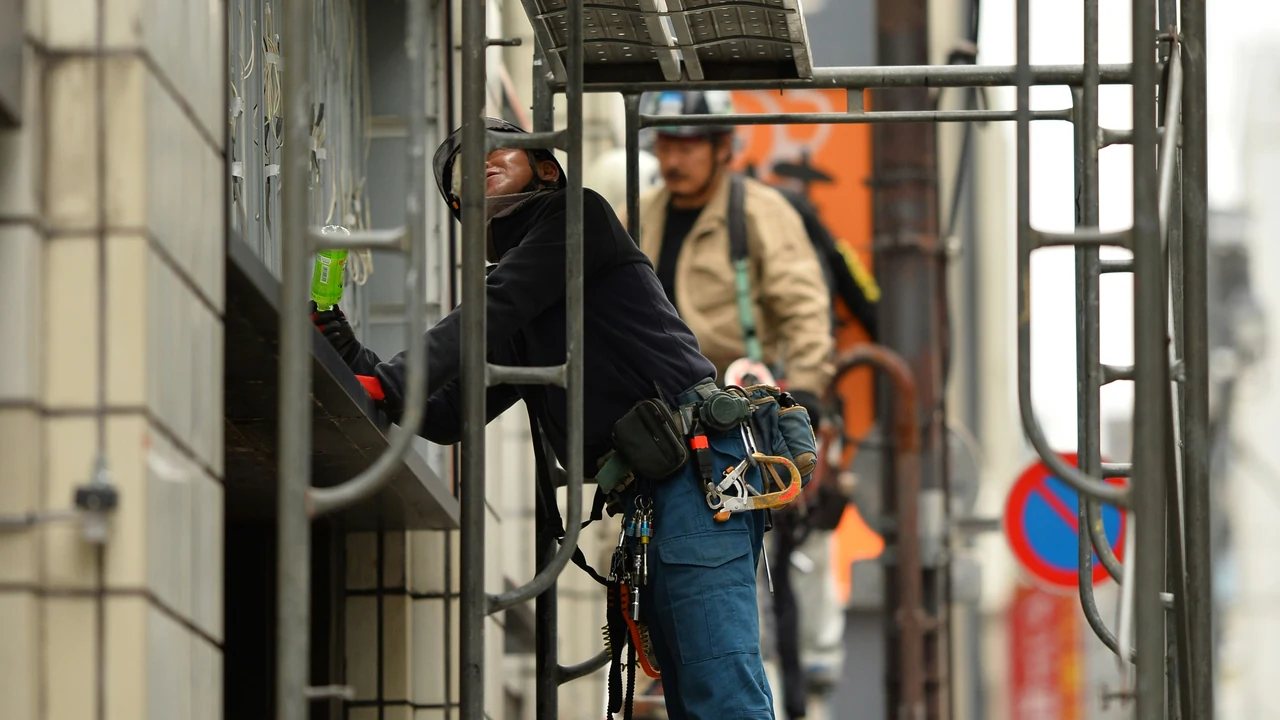 Authentic photograph of two men standing on scaffolding.