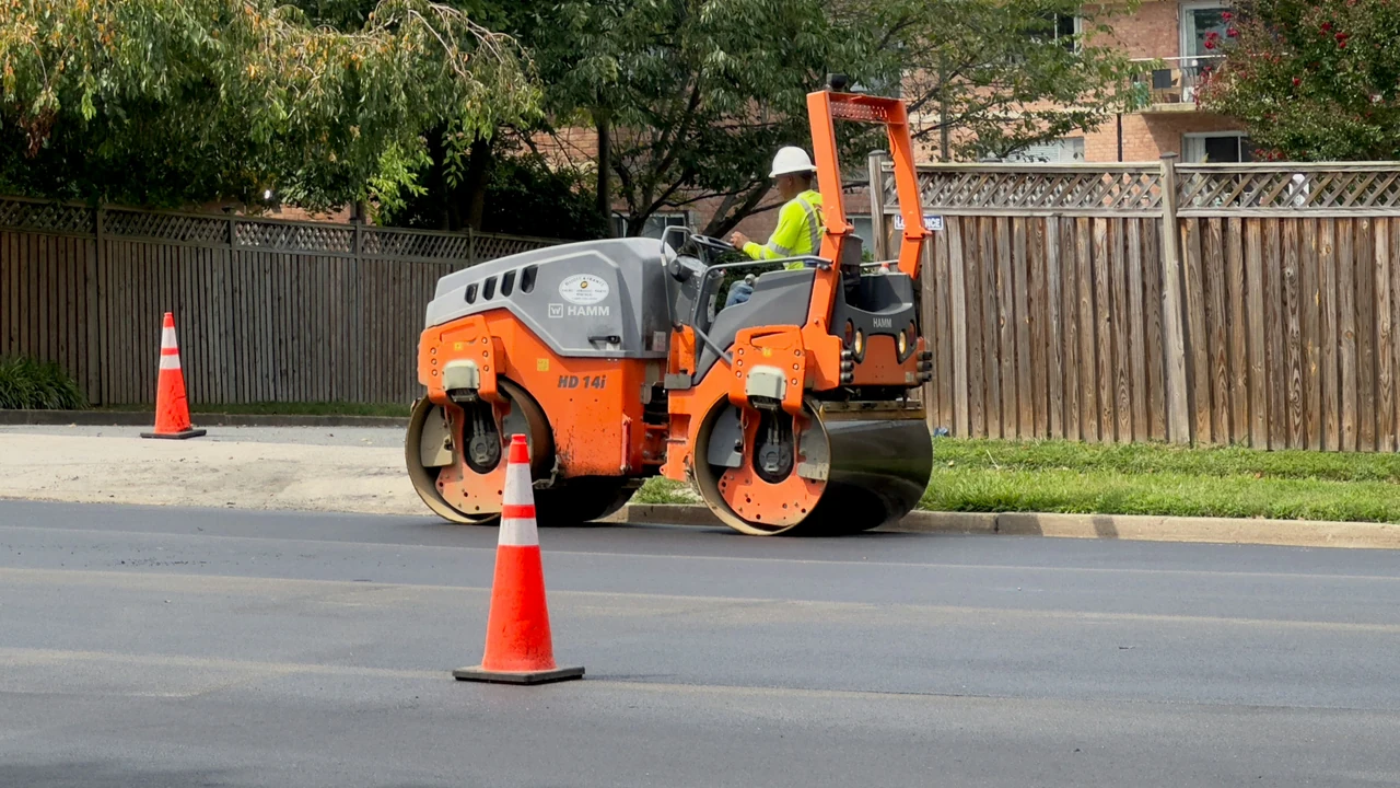 Authentic photograph of a man on a street working on a road.