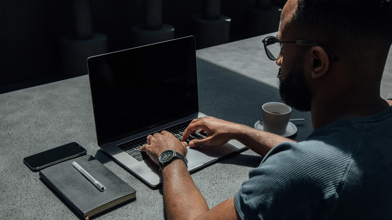 Authentic photograph of man using laptop computer.