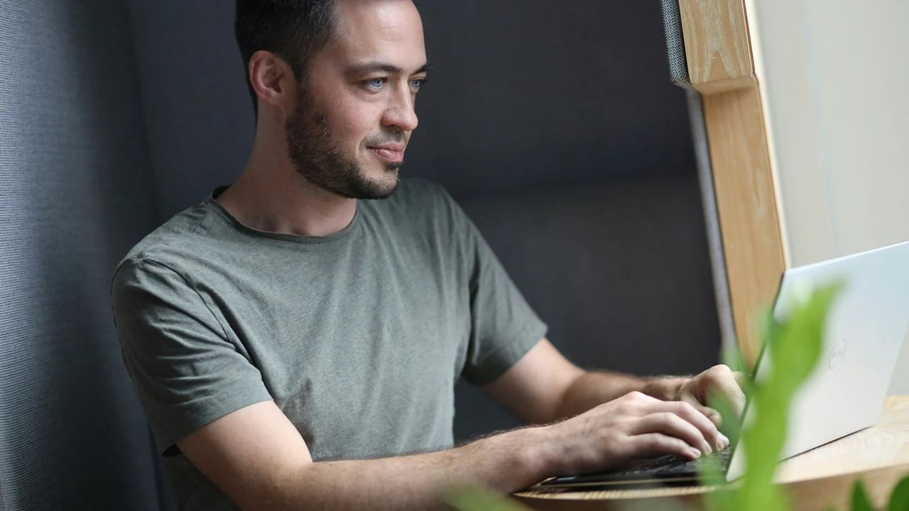 Authentic photograph of a man using a laptop.