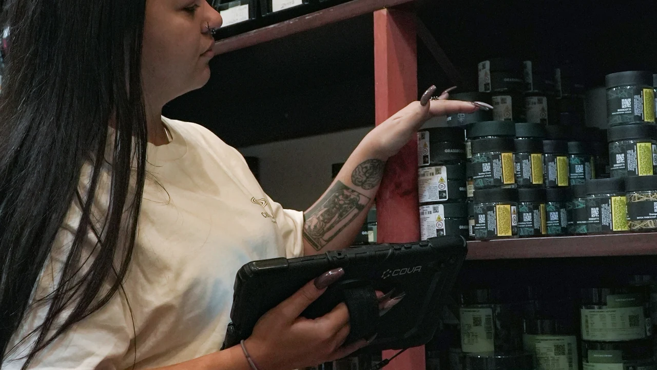 Authentic photograph of woman with tablet checks inventory on shelves.