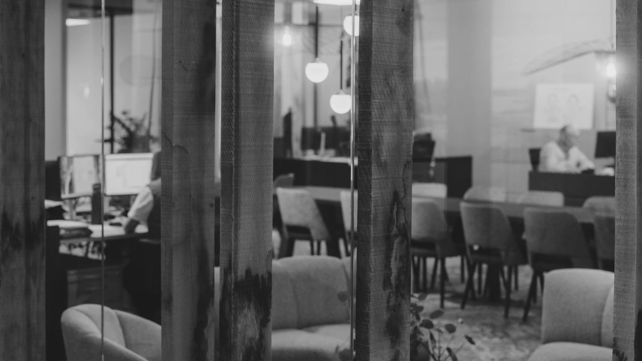 Authentic photograph of modern office lounge area with seating and desks.