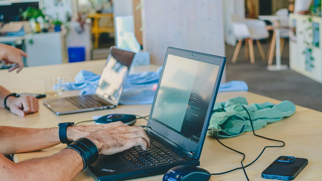 Authentic photograph of people working on laptops at a table.