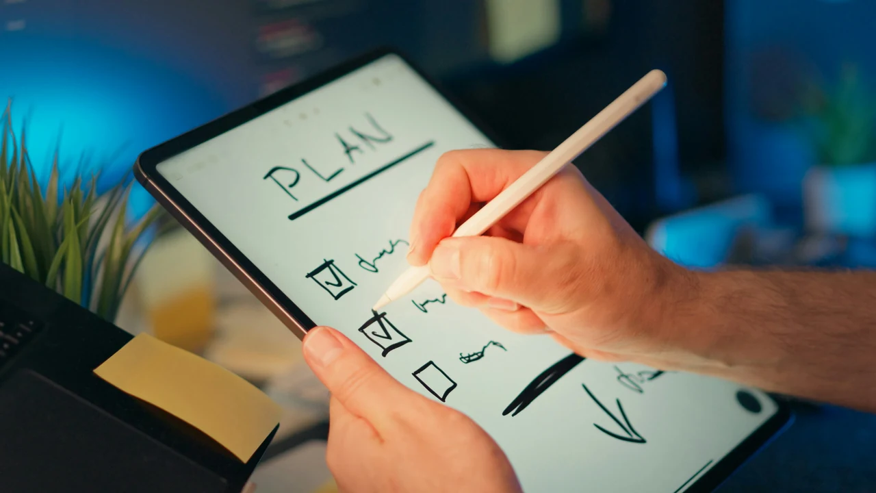 Authentic photograph of someone is writing a plan on a tablet.