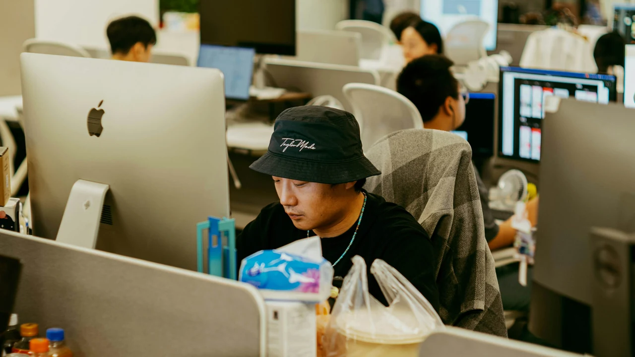 Authentic photograph of people working at computers in a modern office.