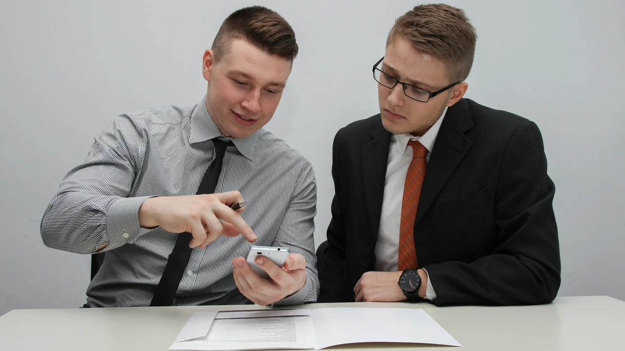 Two man watching smartphone.