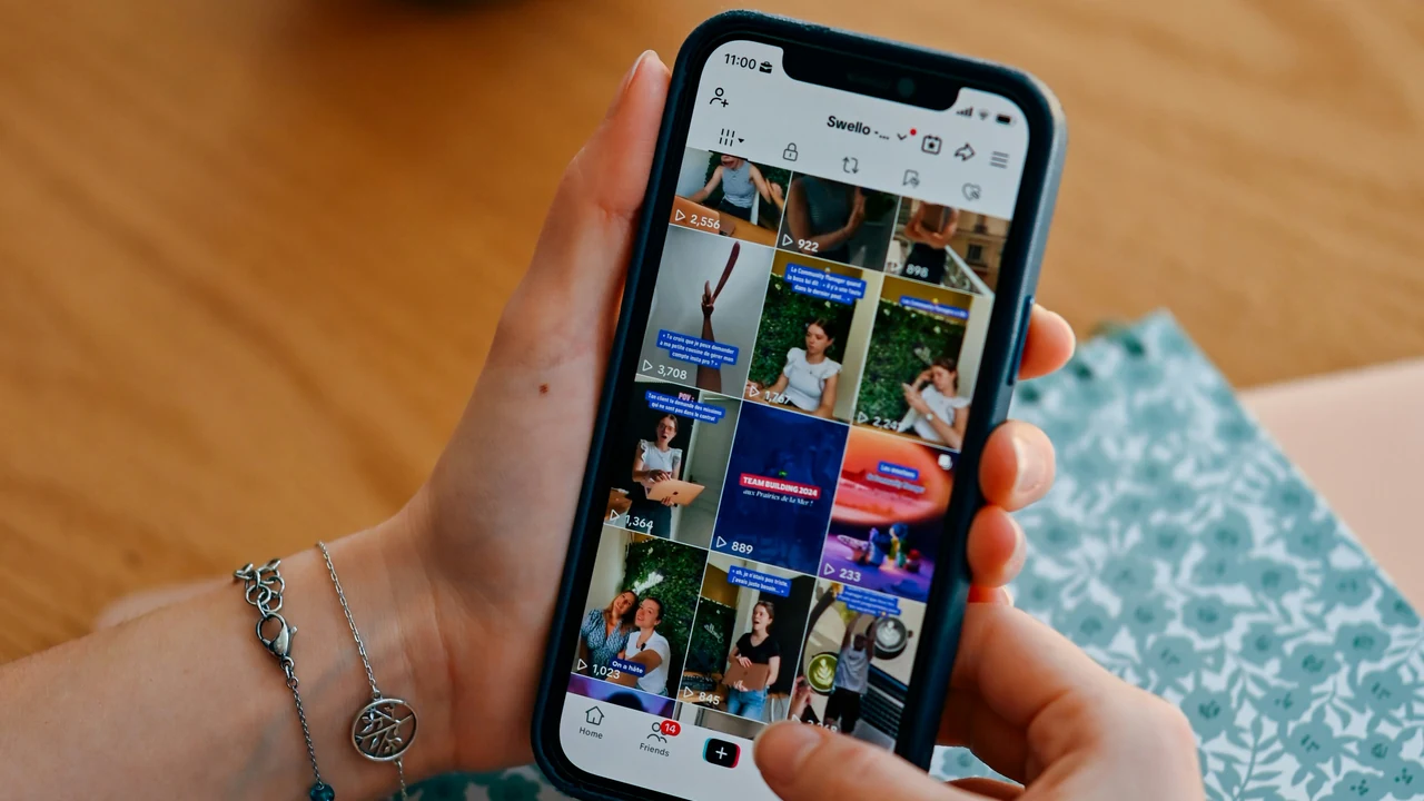 Hands holding smartphone displaying social media feed.