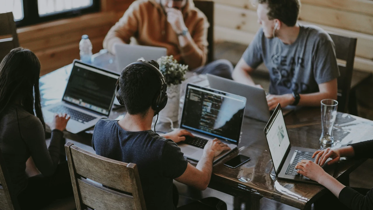 Group of people using laptop computer.