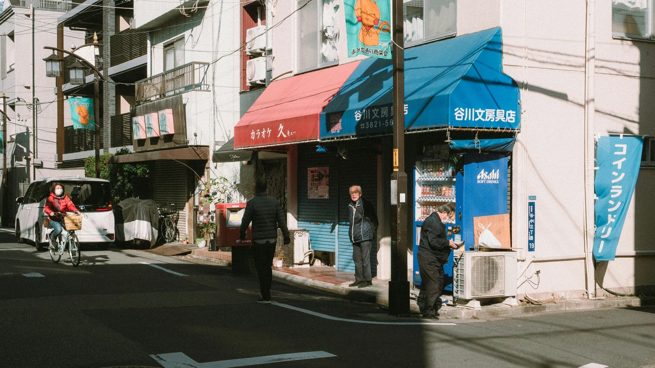 People walking along a neighborhood commercial street.