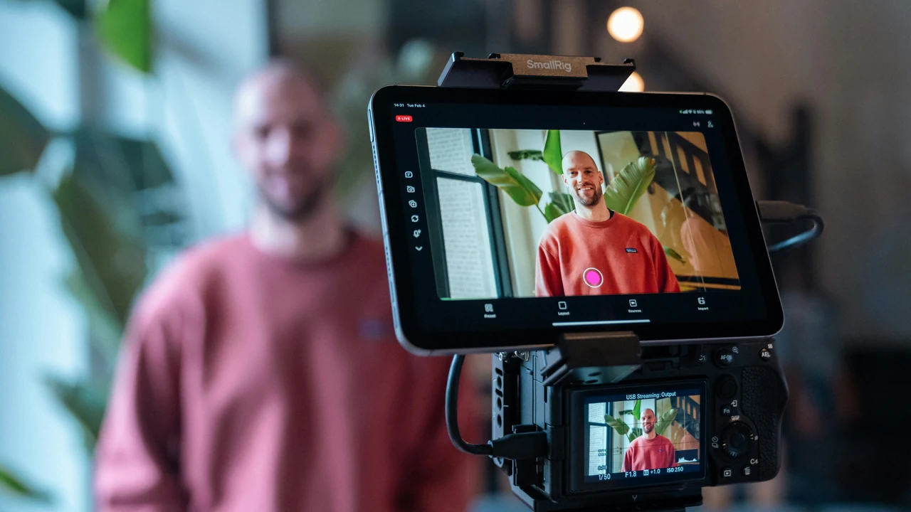 Creator filming social media content with a camera and tablet.