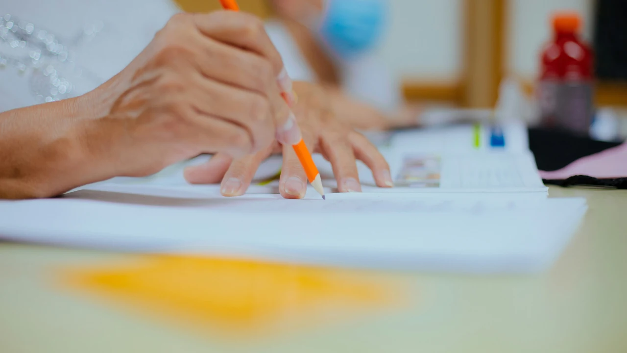 Person writing and revising content at a desk.