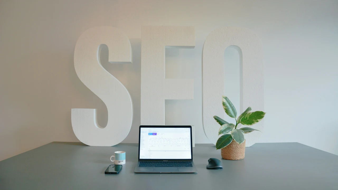 SEO workspace with laptop, coffee, and physical SEO letters on a modern desk.