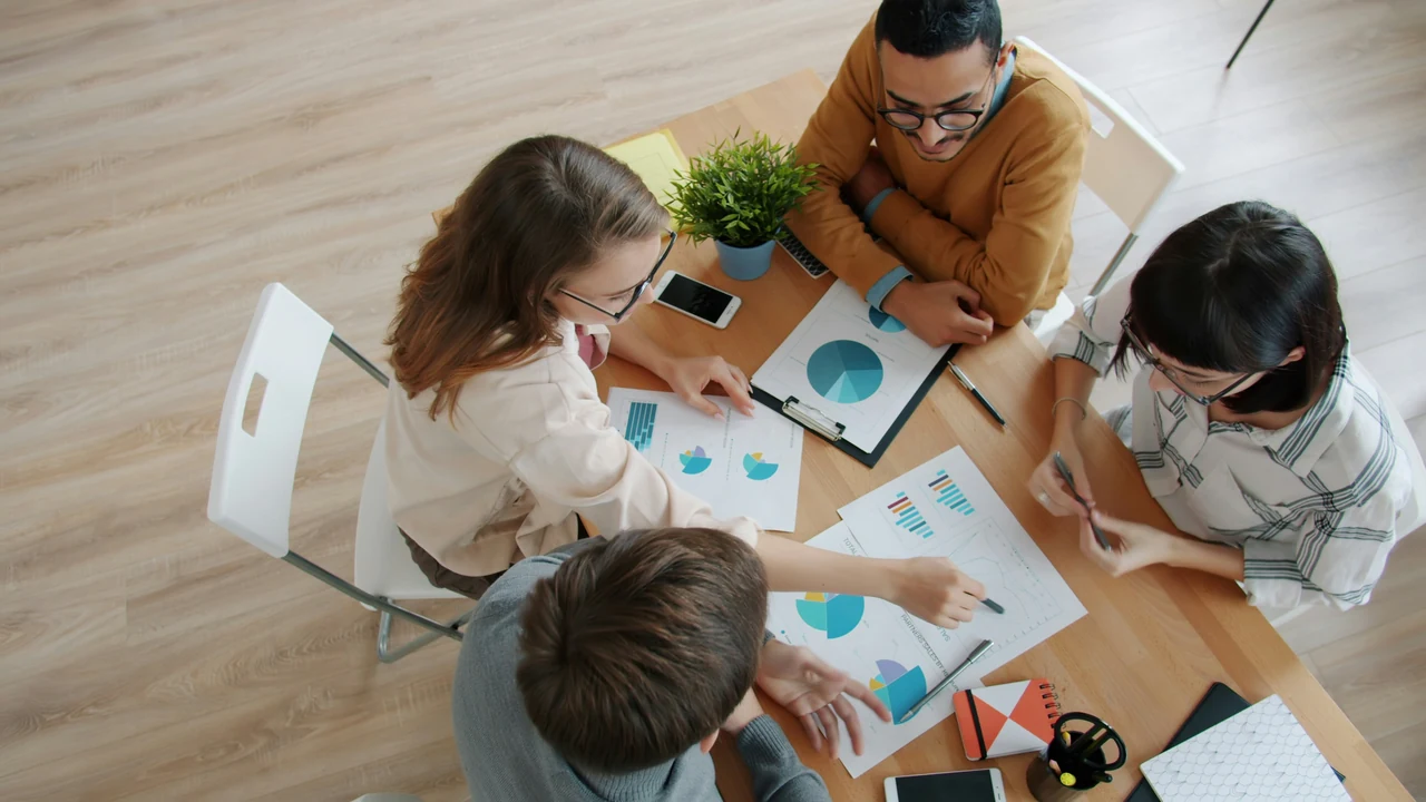 Diverse team reviewing charts around a table.
