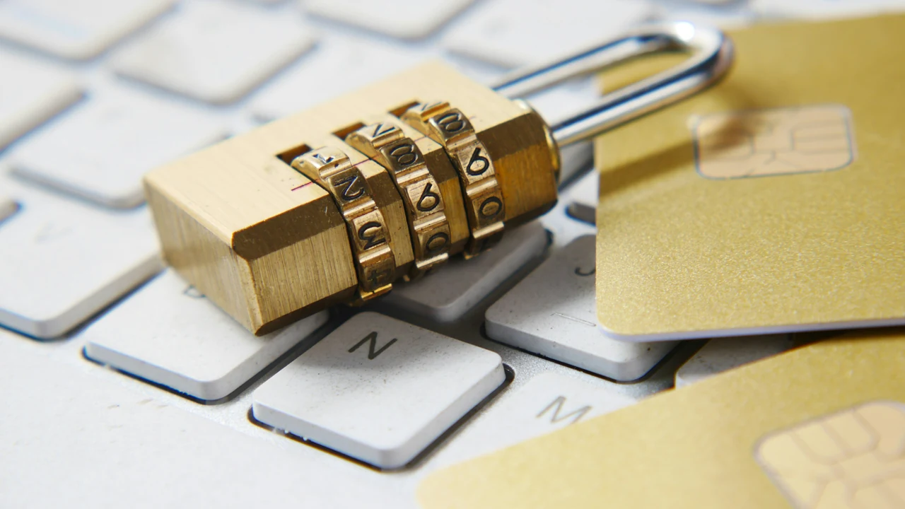 A golden padlock sitting on top of a keyboard.