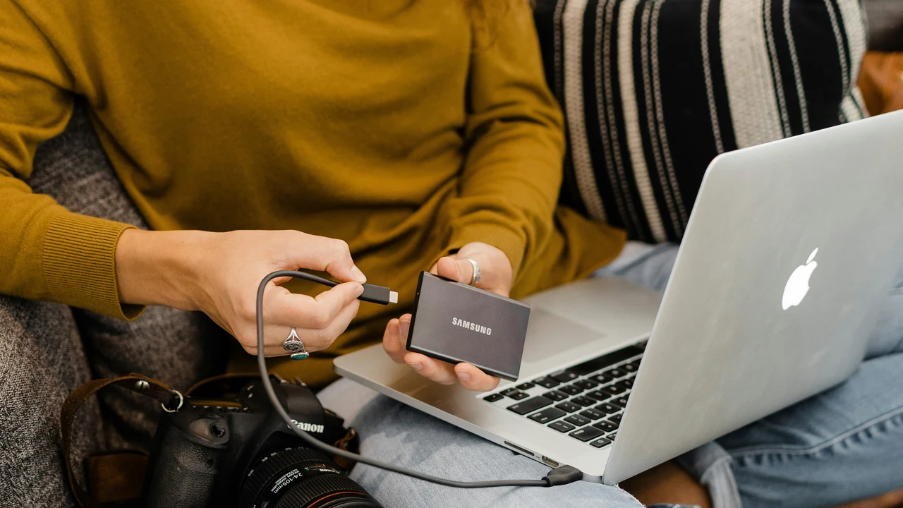 Woman in yellow sweater using silver macbook.