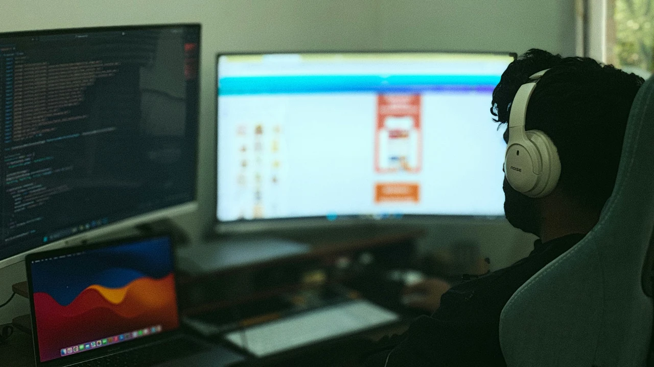 A person works on computer with multiple monitors.