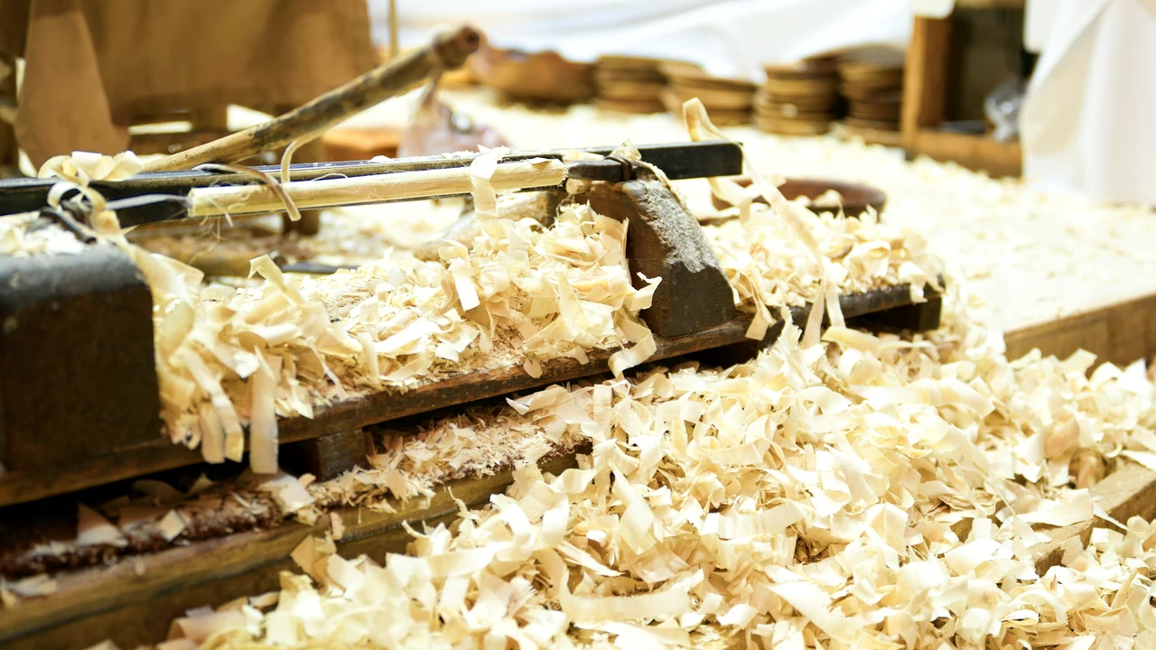 Woodworking hand plane resting among fresh shavings on an artisan bench.